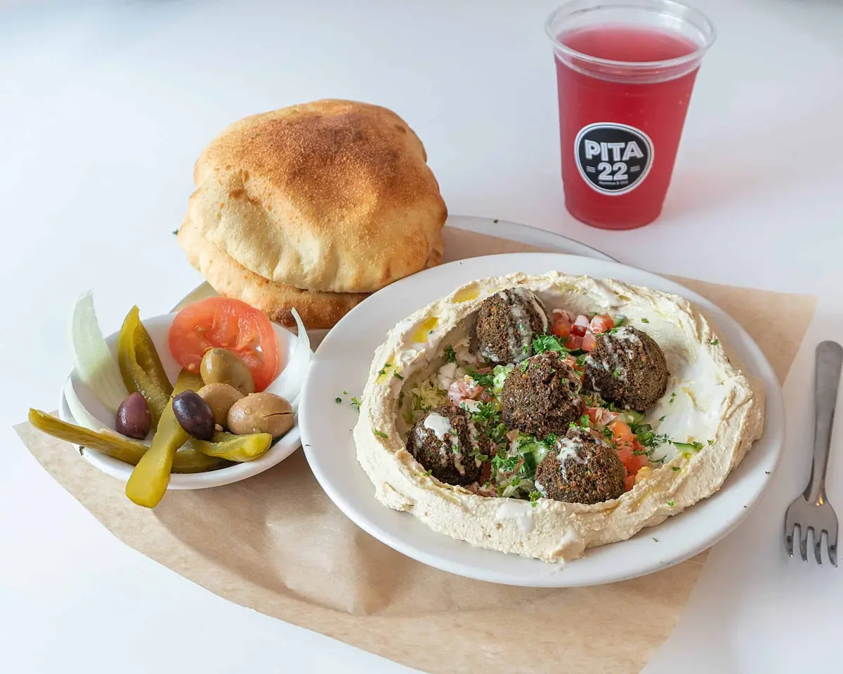Falafel hummus with house-made pita, pickles and a pink lemonade at PITA 22
